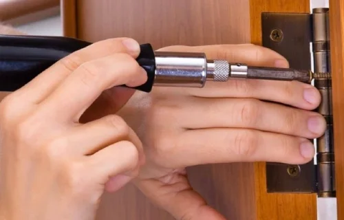 A-person-is-using-a-screwdriver-to-tighten-a-screw-for-a-door-installation
